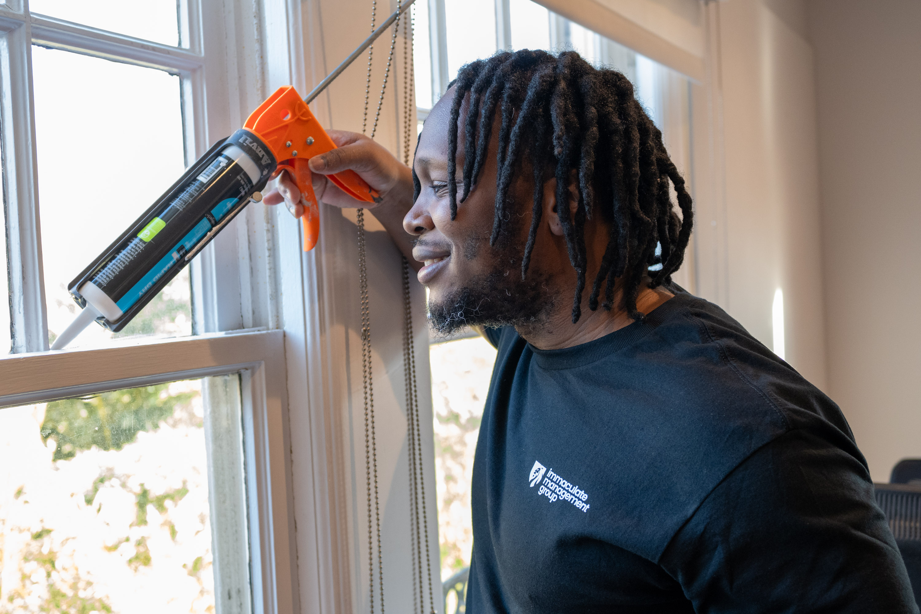 IMG worker performing window caulking